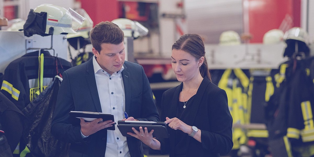Berater besprechen sich in einer Fahrzeughalle einer hauptamtlichen Feuerwehrwache